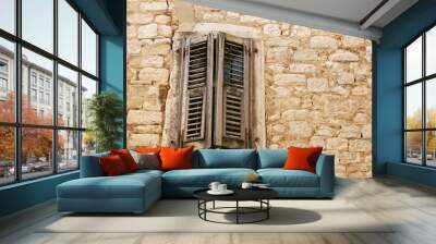 Closed rustic brown wooden window shutters on the background of an old white stone wall. Copy space Wall mural