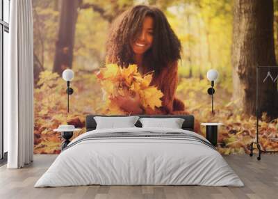 Young black woman relaxing in the autumn forest on a sunny day. Wall mural