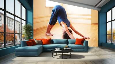 Young caucasian male doing yoga in a yoga studio. Wall mural