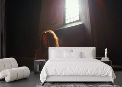 Young Caucasian woman prays in a church.  Wall mural