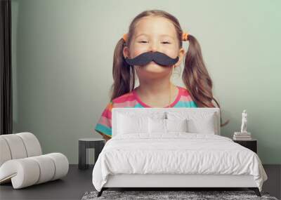 beautiful cute little girl playing with mustache Wall mural