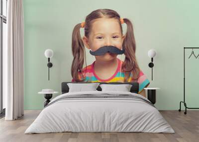 beautiful cute little girl playing with mustache Wall mural