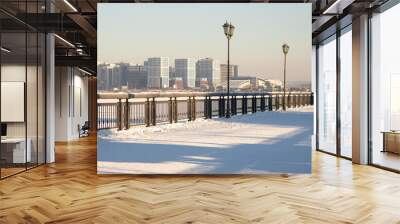 Snow-covered embankment and high-rise buildings in the background Wall mural