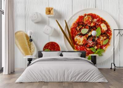 eggplant parmigiana on a white plate, top view Wall mural