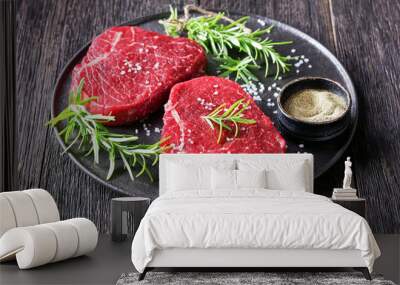 uncooked beef steaks on a black plate Wall mural