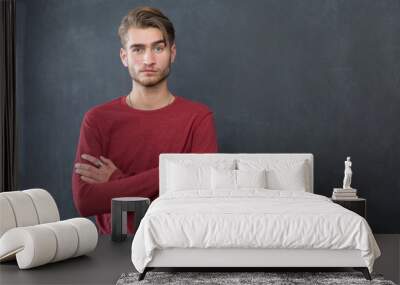 Happy young man standing with arms crossed over blackboard backg Wall mural