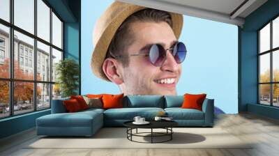 Portrait of an attractive young man laughing against blue backgr Wall mural