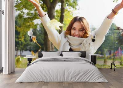 portrait of cheerful young woman with autumn leafs in front of f Wall mural