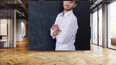 Portrait of young happy smiling teacher man standing near chalkb Wall mural