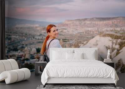 young woman tourist stands against mountain landscape Wall mural