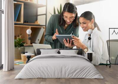 Look at this its hilarious. two businesswomen using a digital tablet to oversee work. Wall mural