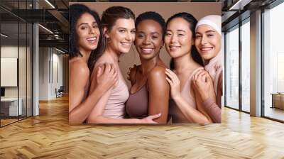 Skincare, diversity and women hug portrait for inclusivity, happiness and healthy skin texture. Interracial beauty and model group with woman in hijab smile for cosmetic campaign in brown studio Wall mural