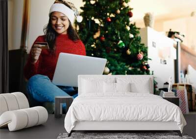 Woman, laptop and online shopping for christmas with credit card in living room. Ecommerce payment, online retail customer and xmas shopping gifts on computer website to celebrate holiday vacation Wall mural