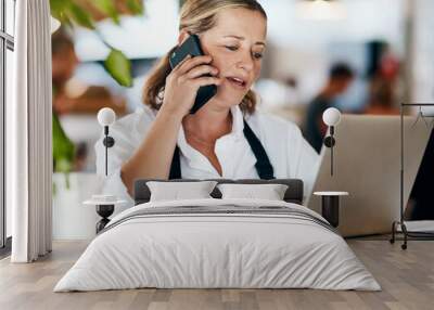 Coffee shop owner on a phone call while working online on her laptop inside a local cafe store. Contact us, learn about us and talk to our baristas, managers and small startup business entrepreneurs Wall mural