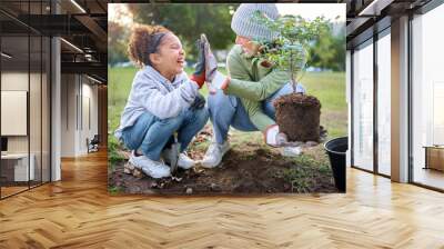 High five, child and woman with plant for gardening at park with trees in nature garden environment. Happy volunteer family planting for growth, ecology and sustainability for community on Earth day Wall mural