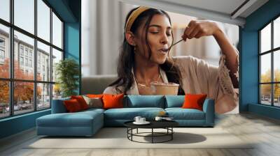 Woman, eating ice cream and living room on sofa, thinking or idea for dessert, sweets or relax in home. Girl, gelato or frozen yogurt for snack, lounge couch and house with memory, choice or decision Wall mural