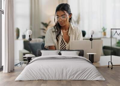 Woman with laptop, notes and typing in home office planning freelance research project at desk. Computer, internet search and thinking, girl with glasses writing online article for remote work job. Wall mural