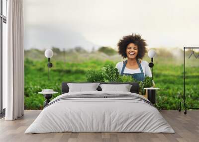 Mother nature provides. Cropped portrait of an attractive young female farmer carrying a crate of fresh produce. Wall mural