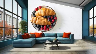 a bowl of fresh fruit and two croissants on marble table Wall mural