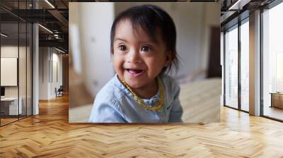 Baby, girl and cute with a down syndrome little child on a bed in the bedroom of her home alone. Children, kids and face with a sweet female kid looking innocent, pure and carefree in her house Wall mural