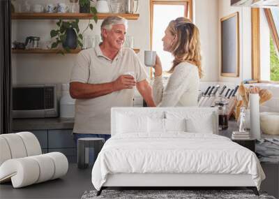 Elderly couple, coffee and kitchen smile, conversation and morning together in their home. Man, woman and retirement in house bonding, happy and relax, talking at breakfast to start day or routine Wall mural