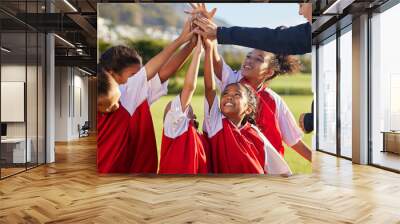 High five, team and girls soccer celebrate a victory and win on field with coach. Sports. young and female children smile, relax and happy they won soccer match with training, teamwork and together. Wall mural