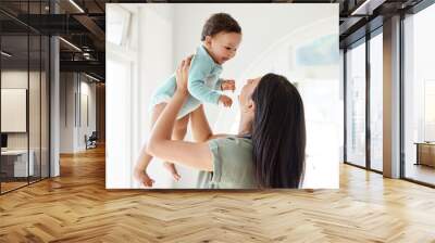 Mom carrying happy baby in home for love, care and quality time together to nurture childhood development. Mother, playing and holding infant kid for support, happiness and funny laughing in house Wall mural