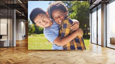 Portrait, children and friends hugging in a park together for fun, bonding or playing in summer. Hug, kids and diversity with boy best friends embracing in a garden in the day during school holidays Wall mural