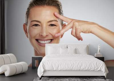 Skincare, beauty and face of mature woman with anti aging product to reduce lines and wrinkles against grey mockup studio background. Portrait of happy model showing care for skin with cosmetology Wall mural