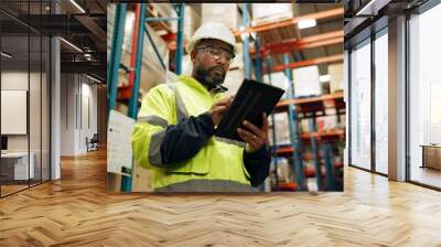 Warehouse, black man and manufacturing with tablet, inventory and checklist in a factory. African person, worker and employee with tech and inspection with digital app for logistics and online stock Wall mural