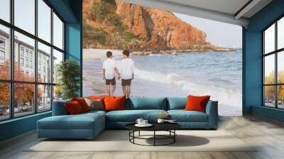 Back view homosexual portrait young asian couple walking with cheerful together on beach in summer, asia gay going tourism for leisure and relax with happiness in vacation at sea, LGBT legal concept. Wall mural