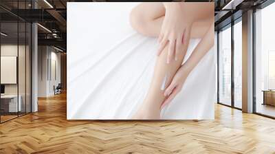 Beautiful asian woman touch skin leg smooth with cream and lotion for hydration and smooth, girl applying body care and cosmetic for silky and soft, beauty perfect with wellness, health and care. Wall mural