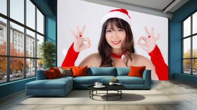 Beautiful portrait young asian woman Santa costume smiling gesture ok sign with happy in holiday xmas, beauty asia girl cheerful and happiness celebrating in Christmas isolated on white background. Wall mural