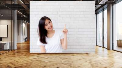 portrait of beautiful asian woman happiness standing finger pointing something on gray cement textur Wall mural