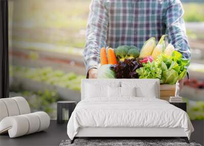 Portrait young asian man smiling harvest and picking up fresh organic vegetable kitchen garden in basket in the hydroponic farm, agriculture and cultivation for healthy food and business concept. Wall mural