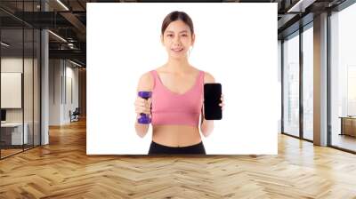 Portrait young asian woman lifting dumbbell and showing smartphone isolated white background, female fitness workout training holding dumbbell for muscle strong and strength, sport and health care. Wall mural