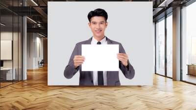 Young asian business man showing empty signboard for advertising isolated on white background, businessman confident holding billboard banner for presenting with copy space, success and achievement. Wall mural