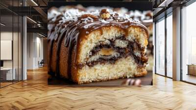 A moist swirl cake topped with chocolate drizzle and shredded coconut, featuring a rich chocolate and caramel filling, garnished with pecans. Wall mural