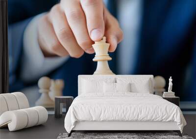 A person moves a white king chess piece on a chessboard, captured in a strategic moment during a game of chess. Wall mural