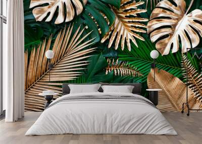 closeup nature view of gold and green tropical monstera and palm leaves. Creative nature pattern background.  Flat lay. Wall mural