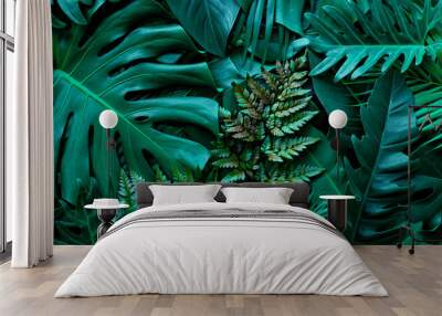 closeup nature view of green monstera leaf and palms background. Flat lay, dark nature concept, tropical leaf Wall mural