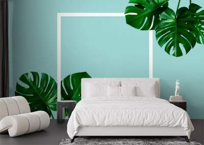 top view of tropical monstera leaf shadow with white frame on blue color background. minimal summer concept. flat lay Wall mural