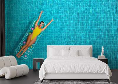 amazing beautiful girl in a yellow bikini air mattress swims in the pool of a luxury hotel, summer vacation, happiness, travel, smile joy, listening to music, drinking cocktail, top view Wall mural