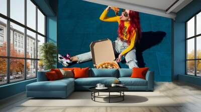 Bright exciting girl with red hair, style of the 90s, 2000s, jacket, wide jeans, bananas, sneakers. Eats pizza out of the box on a basketball court in summer Wall mural