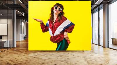 Cheerful gorgeous girl in clothes in the style of the 90s, with a vintage cassette player and headphones, in the studio on a white background. Music, emotions, fashion Wall mural