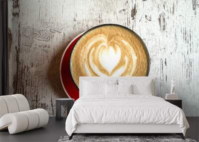 Closeup red cup of  coffee with heart art decoration on a bright wooden table Wall mural