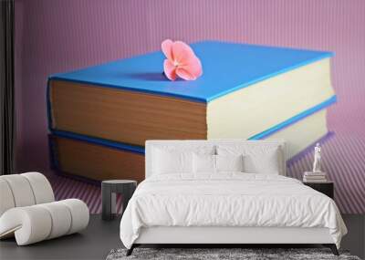 Books and pink flower on pink background. Wall mural