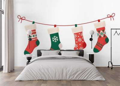 Christmas stockings with various traditional colorful holiday ornaments. Hanging children clothing elements with cute xmas patterns on rope. Red, green socks with snowflakes, snowman, christmas tree Wall mural