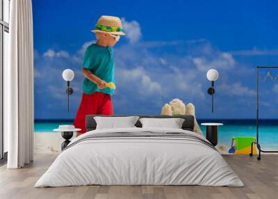 child building sand castle on tropical beach Wall mural