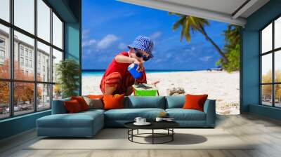 child building sand castle on tropical beach Wall mural